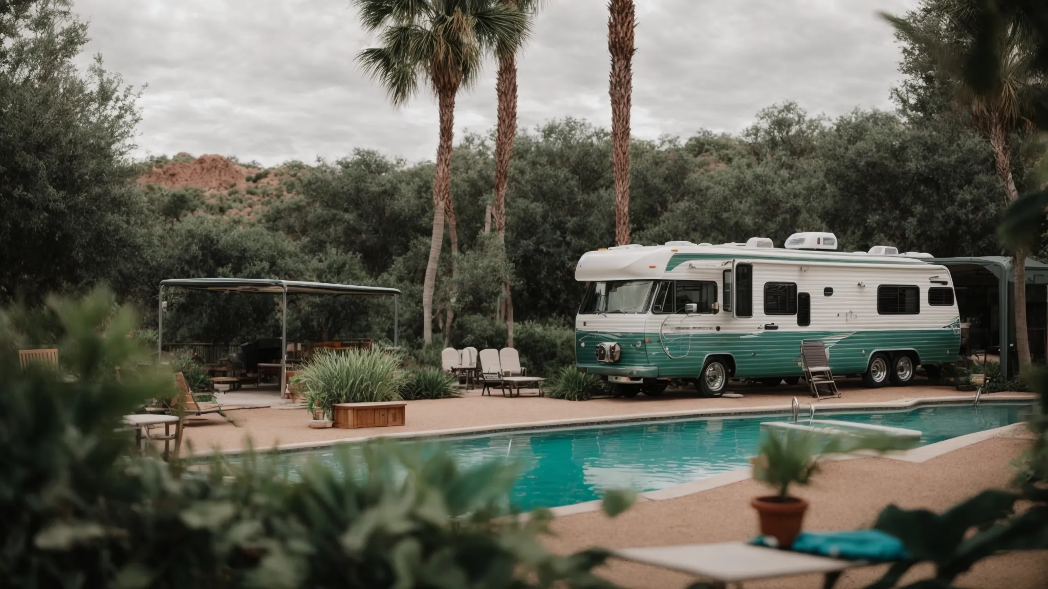 an rv parked beside a lush, green recreation area with a swimming pool and a dog park visible in the background.