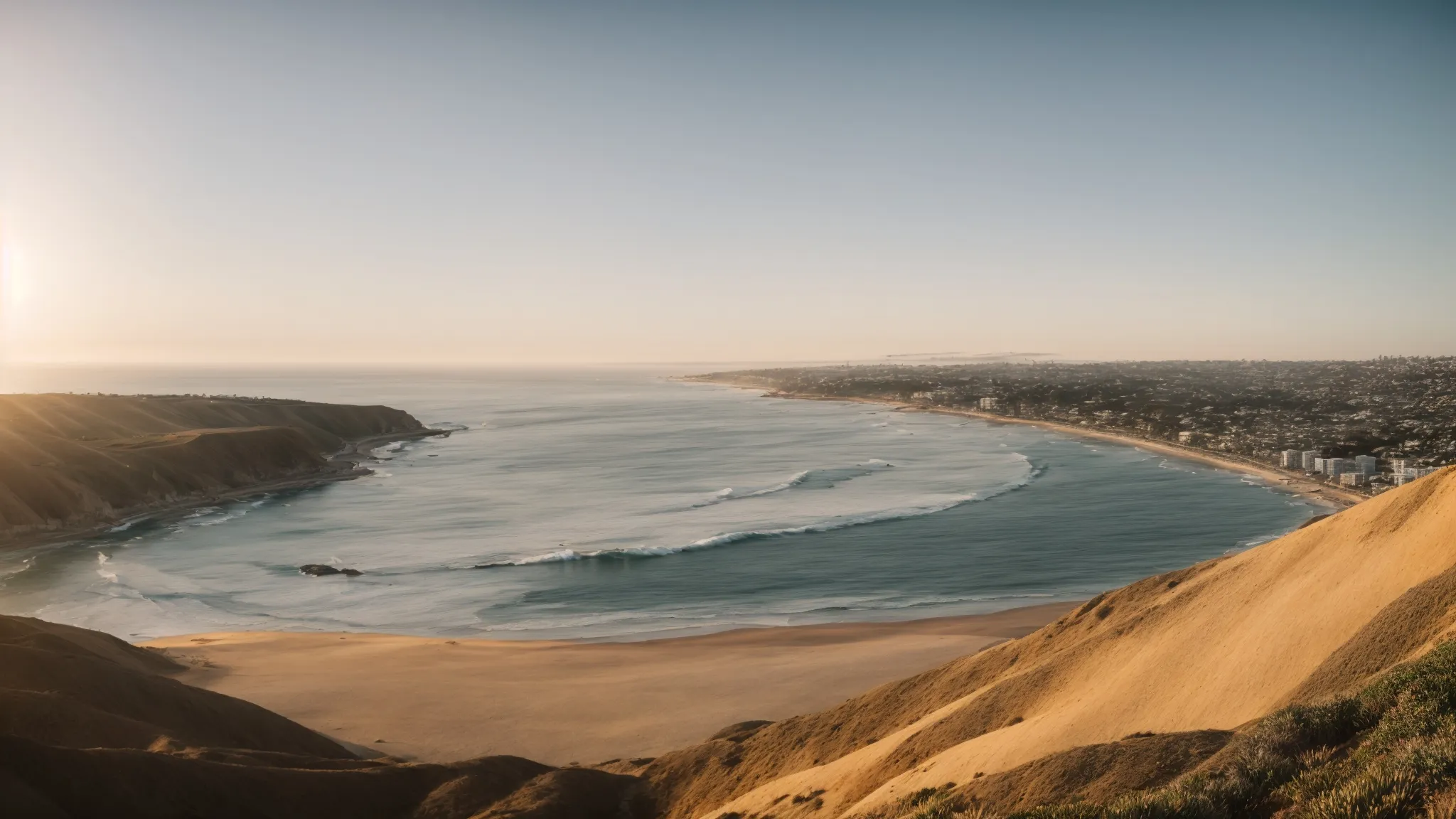 a panoramic view of san diego's coastline bathed in golden light with the pacific ocean extending to the horizon.