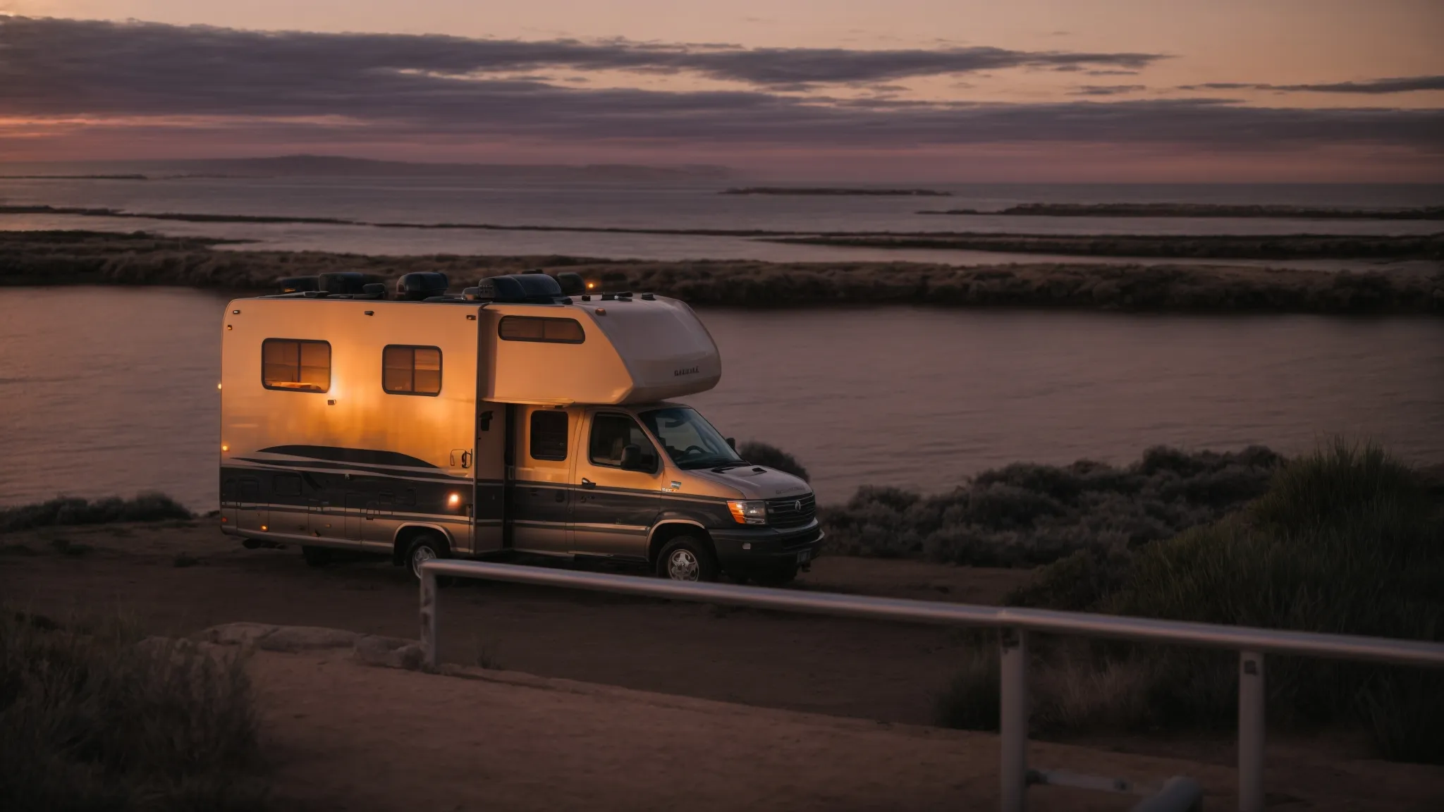 an affordable rv is parked with the sun setting over the san diego coastline in the background.