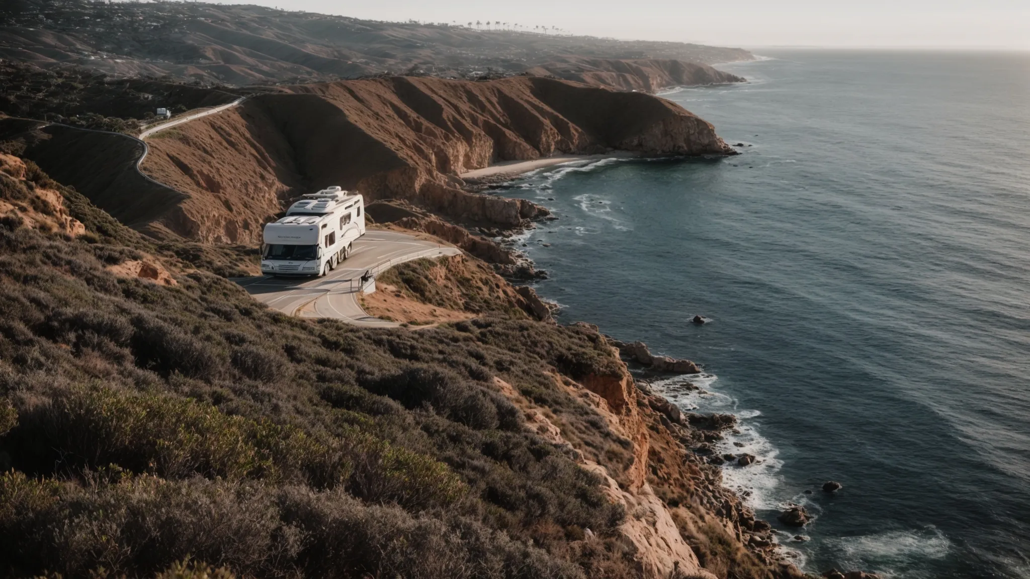 an rv parked by a coastal lookout, overlooking the expansive blue sea and sunlit cliffs of san diego.