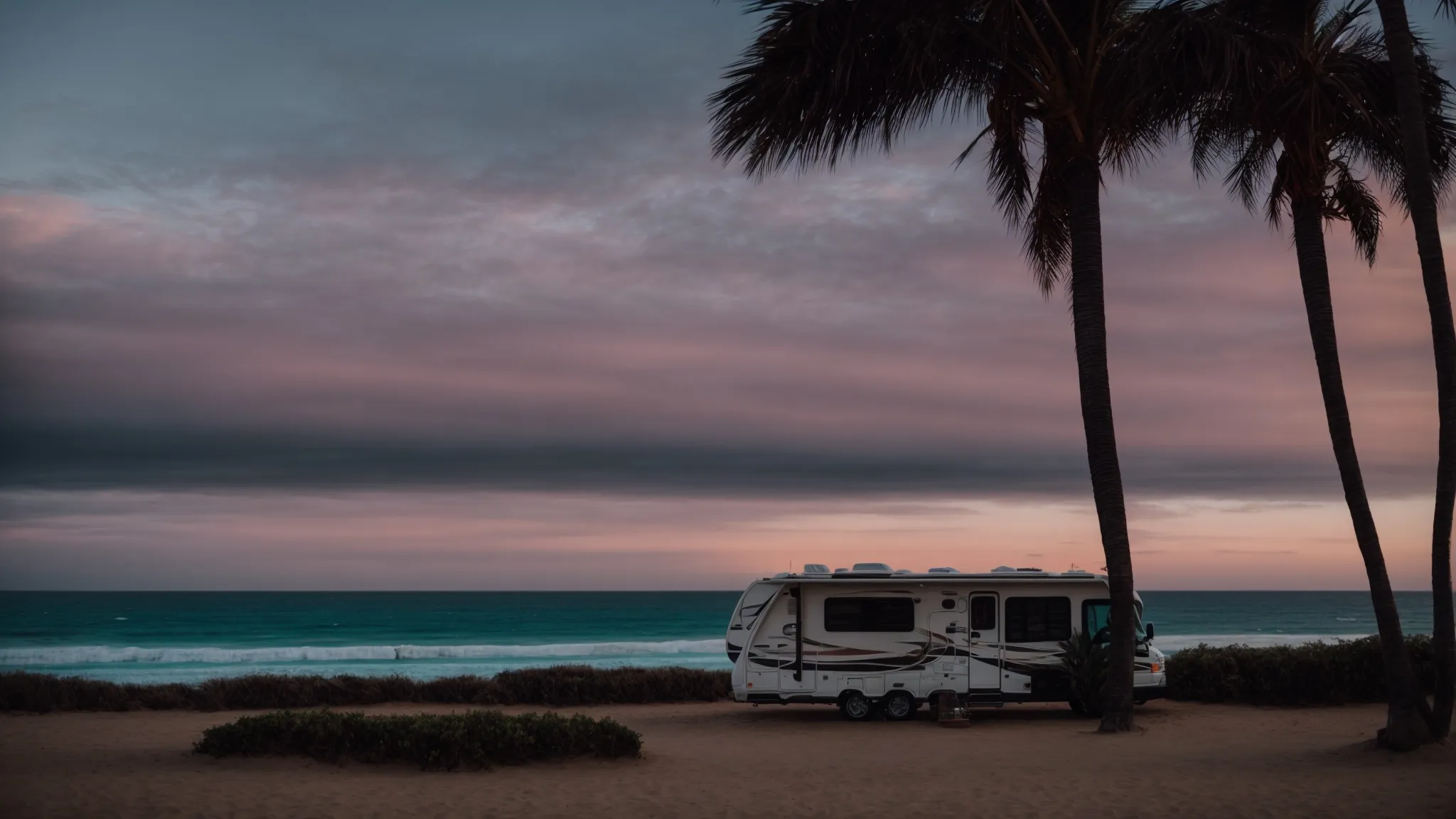 an rv parked on a serene beachfront at sunset, with the pacific ocean in the backdrop.